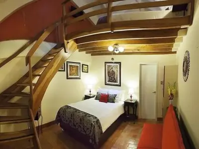 a bedroom with a bed and a spiral staircase at Tandapata Boutique Hotel in Cusco