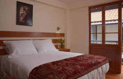 a bedroom with a large bed and a window at Tandapata Boutique Hotel in Cusco