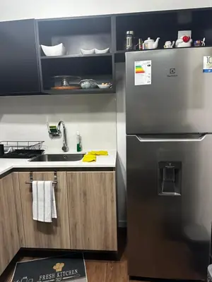 a kitchen with a stainless steel refrigerator and a sink at Departamento Calido y familiar in Lima
