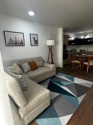 a living room with a couch and a dining room at Departamento Calido y familiar in Lima