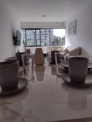 a dining room with a table with cups and chairs at Bella vista al mar de Lima - Miraflores in Lima