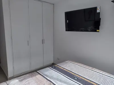 a bedroom with a bed with a flat screen tv at Bella vista al mar de Lima - Miraflores in Lima