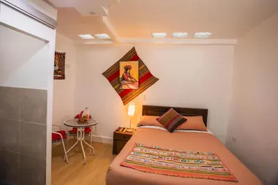 a small bedroom with a bed and a table at RumiUma Boutique Hotel in Cusco
