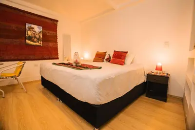 a bedroom with a large bed and a chair at RumiUma Boutique Hotel in Cusco