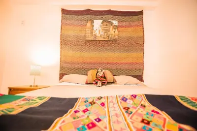 a bed with a colorful blanket on top of it at RumiUma Boutique Hotel in Cusco