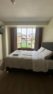a bedroom with a large bed with a large window at La Herencia - Oxapampa in Oxapampa