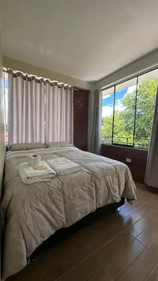 a bedroom with a large bed with two towels on it at La Herencia - Oxapampa in Oxapampa