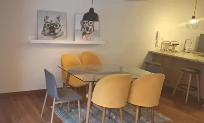 a dining room with a glass table and yellow chairs at Gorgeous 2BDRM with A/C - Miraflores in Lima