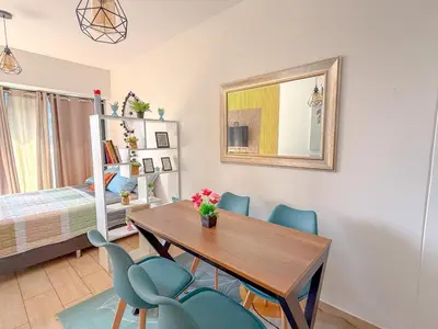 a dining room with a table and chairs and a bed at Departamento exclusivo a un paso de San Isidro in Lima
