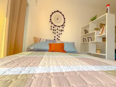 a bedroom with a bed with an orange pillow on it at Departamento exclusivo a un paso de San Isidro in Lima