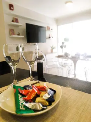 a plate of food and two wine glasses on a table at Refugio en Barranco, Private Apartament in Barranco in Lima