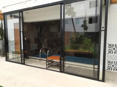 a glass door with a bench in front of a building at Refugio en Barranco, Private Apartament in Barranco in Lima