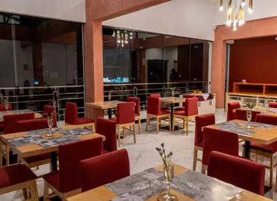 a restaurant with wooden tables and red chairs at Mamasara Machupicchu in Machu Picchu