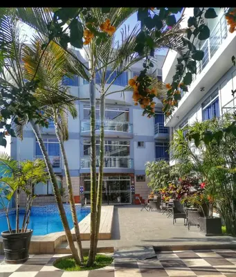 a hotel courtyard with palm trees and a swimming pool at GRAN HOTEL VILLA DEL SUR in San Vicente de Cañete