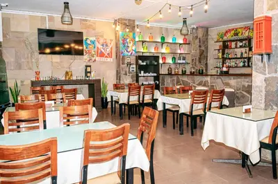 a restaurant with tables and chairs and a bar at GRAN HOTEL VILLA DEL SUR in San Vicente de Cañete