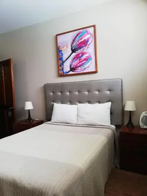 a bed in a bedroom with two lamps and a painting at GRAN HOTEL VILLA DEL SUR in San Vicente de Cañete