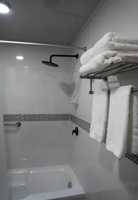 a white bathroom with a tub and towels at Hotel Tierra Inka Sacred Valley in Ollantaytambo