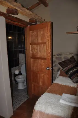 a bathroom with a bed and a toilet in a room at Valle Dorado Lodge in Cusco