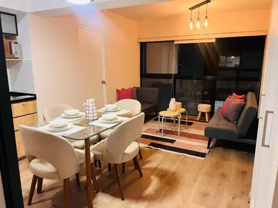a dining room and living room with a table and chairs at MONTERRICO POLO APARTS #13 - DPTO 2 dorm - Frente Embajada USA in Lima
