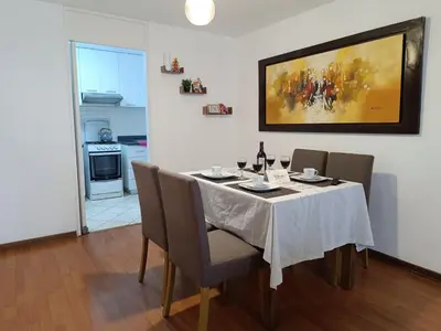 a dining room with a table with chairs and a painting at Runawasi Apartments - José Gonzales 3BDR, near to Larcomar in Lima