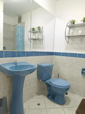a bathroom with a blue toilet and a sink at Runawasi Apartments - José Gonzales 3BDR, near to Larcomar in Lima