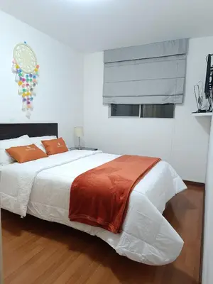 a bedroom with a large white bed with orange pillows at Runawasi Apartments - José Gonzales 3BDR, near to Larcomar in Lima