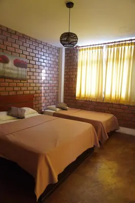 a bedroom with two beds and a brick wall at La Fogata del Sur in Fundo Copacabana