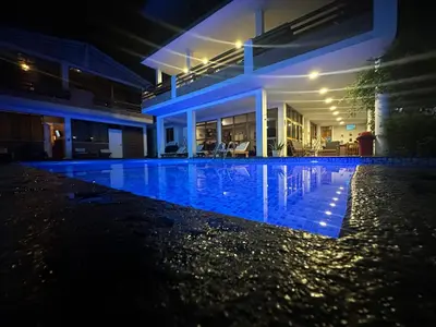 a swimming pool in front of a house at night at La Fogata del Sur in Fundo Copacabana