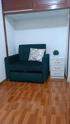 a green couch in a living room with a wooden floor at Mini Apartamento Vista Verde in Lima