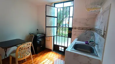 a kitchen with a sink and a table and a window at Mini Apartamento Vista Verde in Lima