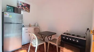 a kitchen with a refrigerator and a table and chairs at Mini Apartamento Vista Verde in Lima