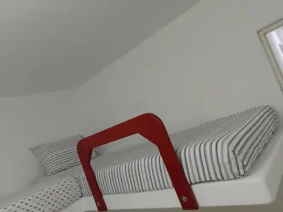 a red chair sitting on a bed in a room at Departamento en playa Chocaya. Disfruta del mar, la piscina y la tranquilidad. in Asia