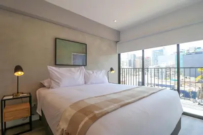 a bedroom with a large bed and a large window at Alameda by Wynwood House in Lima