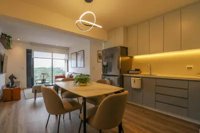 a kitchen and living room with a table and chairs at Alameda by Wynwood House in Lima