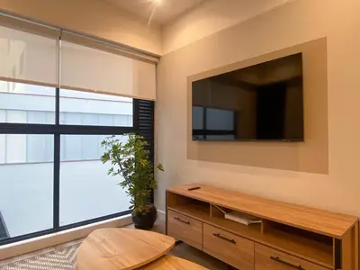 a living room with a large flat screen tv on the wall at Alameda by Wynwood House in Lima