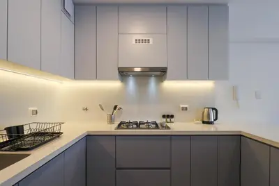a kitchen with white cabinets and a stove top oven at Alameda by Wynwood House in Lima