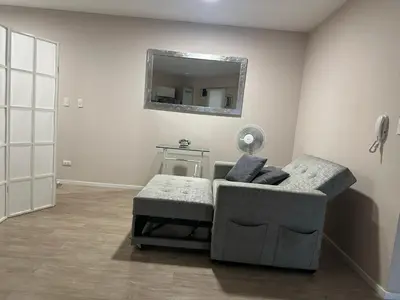 a living room with a chair and a mirror at Friendly Apartment Tamayo in Lima