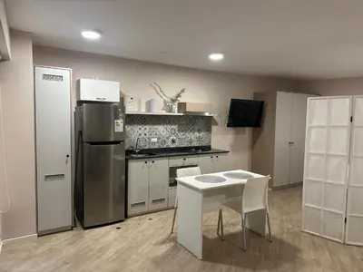 a kitchen with a stainless steel refrigerator and a table at Friendly Apartment Tamayo in Lima