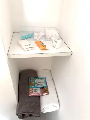 a shelf in a bathroom with a book and towels at Friendly Apartment Tamayo in Lima