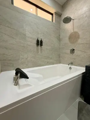 a white bath tub in a bathroom with a black telephone at Los Andes - Restaurant & Bungalows in Cieneguilla
