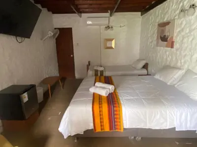 a bedroom with a large white bed with towels on it at Los Andes - Restaurant & Bungalows in Cieneguilla