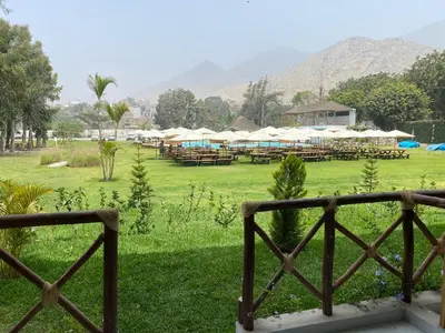 a view of a field with tables and umbrellas at Los Andes - Restaurant & Bungalows in Cieneguilla
