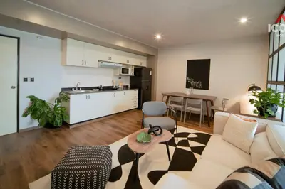 a living room with a couch and a table and a kitchen at Designed Studio in Miraflores / Amazing View in Lima