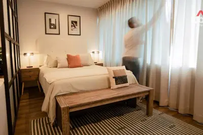a bedroom with a bed and a person standing in the window at Designed Studio in Miraflores / Amazing View in Lima
