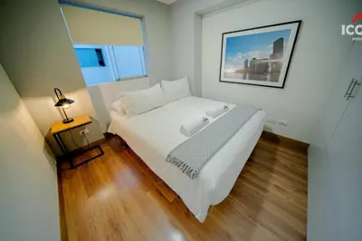 a large white bed in a room with a lamp at Beautiful 2BR in Miraflores in Lima