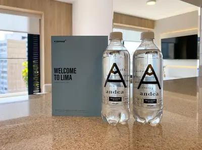 two water bottles on a counter next to a welcome to illima sign at Los Pinos by Wynwood House in Lima