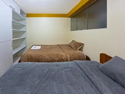 a bedroom with two beds and a tv at Killa Anqas - Departamento en el centro del Cusco in Cusco