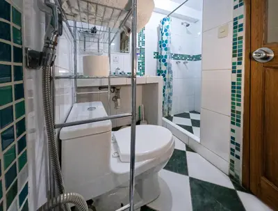 a small bathroom with a toilet and a shower at Killa Anqas - Departamento en el centro del Cusco in Cusco