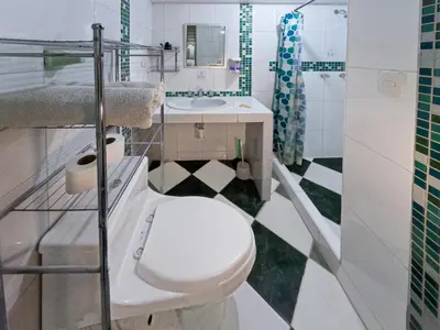 a white bathroom with a toilet and a sink at Killa Anqas - Departamento en el centro del Cusco in Cusco