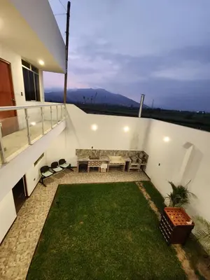 a balcony with a couch and a grass yard at Casa de Campo El Huerto in Lima
